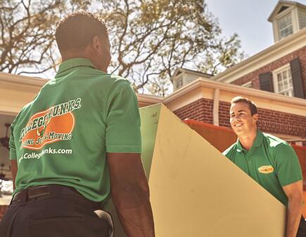two college hunks moving a dresser